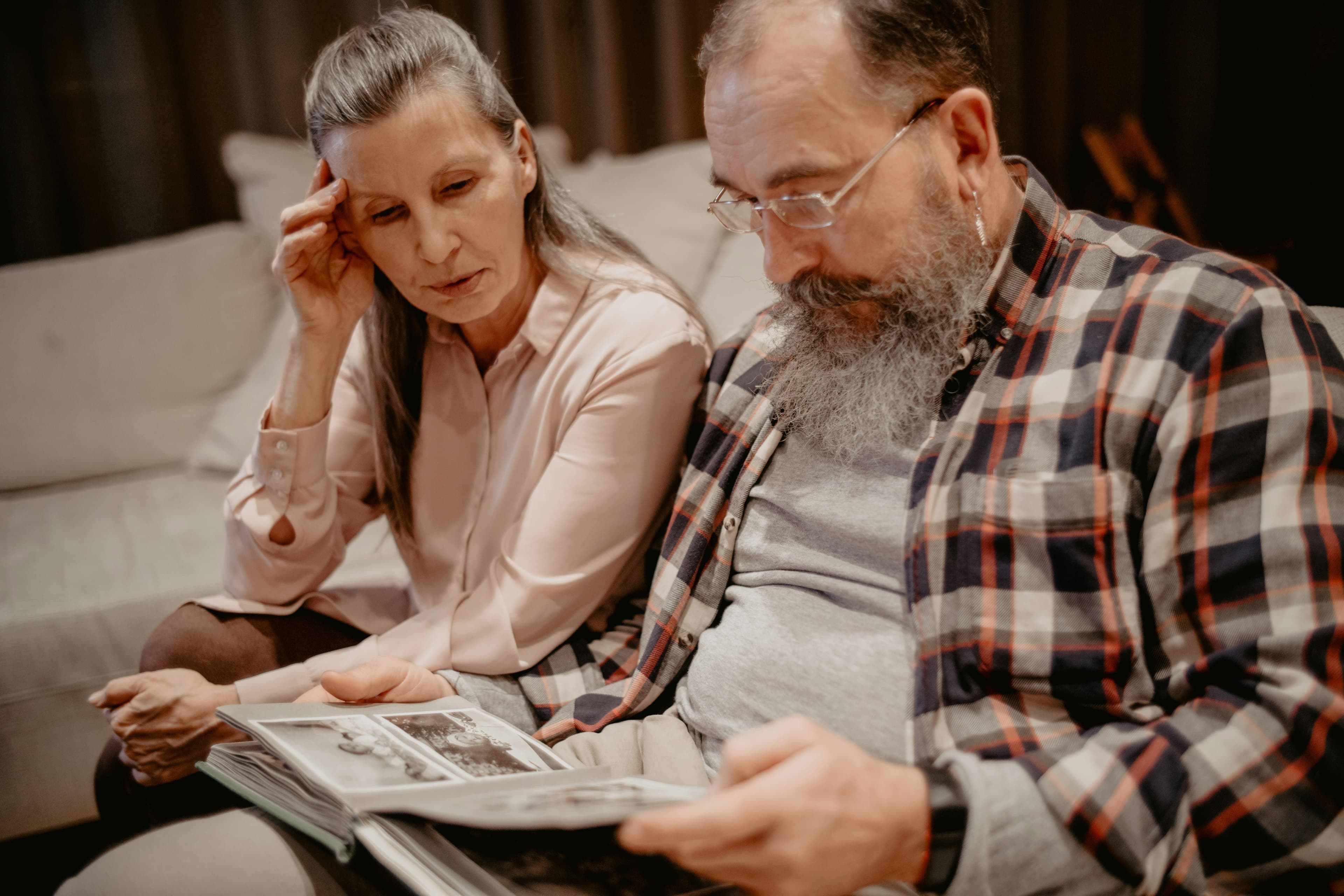 An older couple looking through a family photo album together